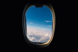 Looking out a plane window, showcasing our ability to offer travel insurance